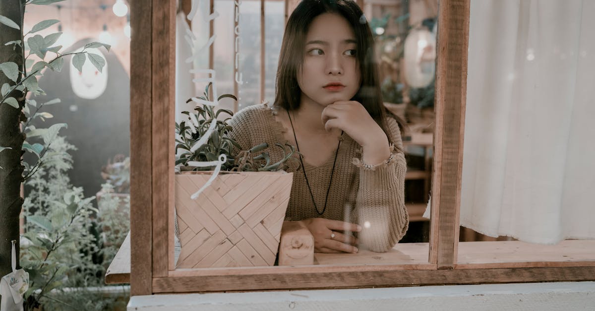 Young woman sitting thoughtfully at a cafe window