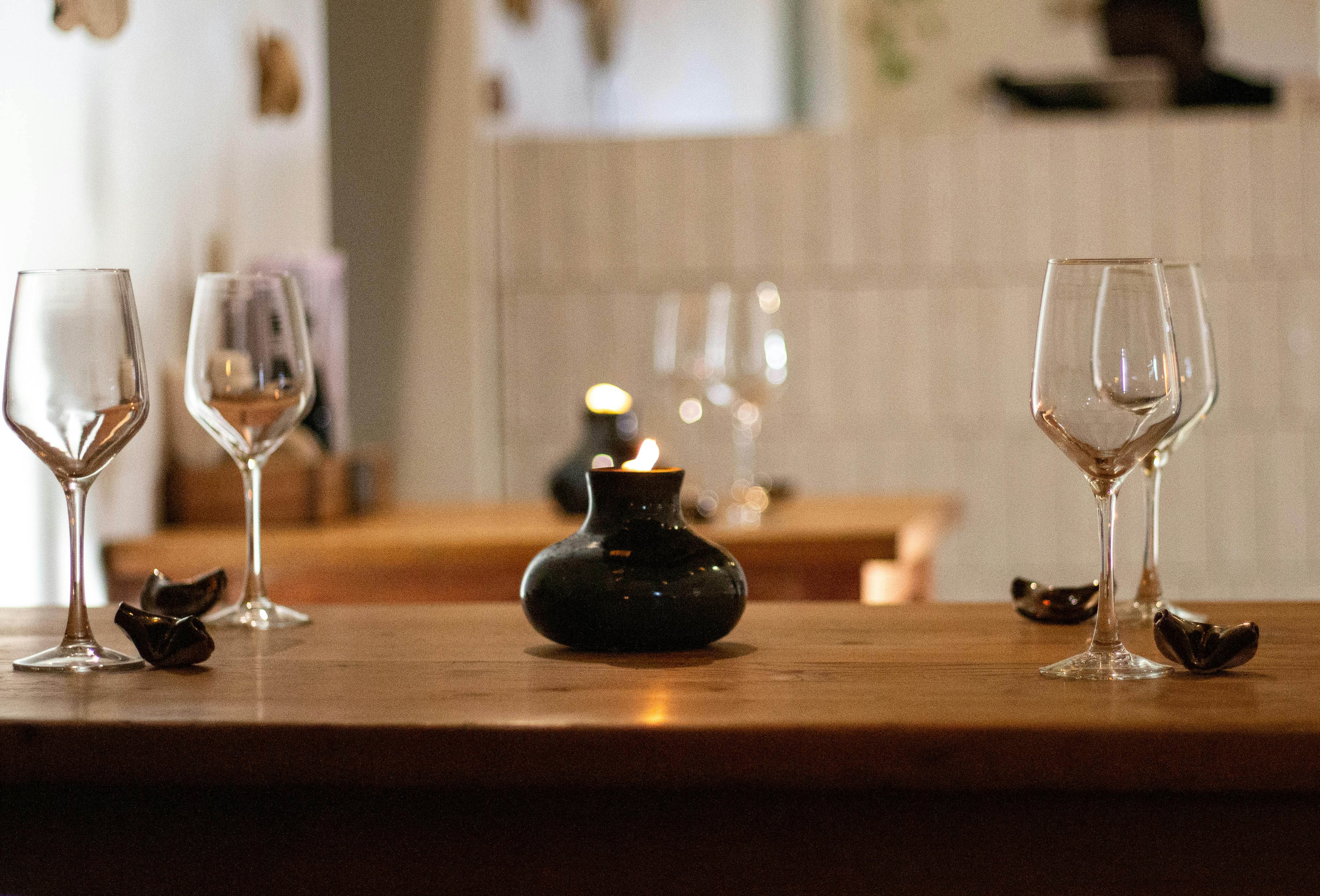An intimate restaurant table set with empty wine glasses and warm candlelight